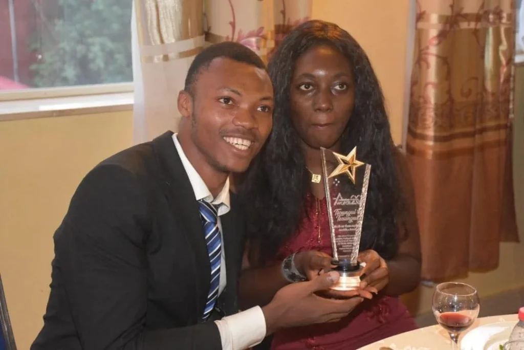 Un lauréat et sa compagne posent avec le trophée en verre