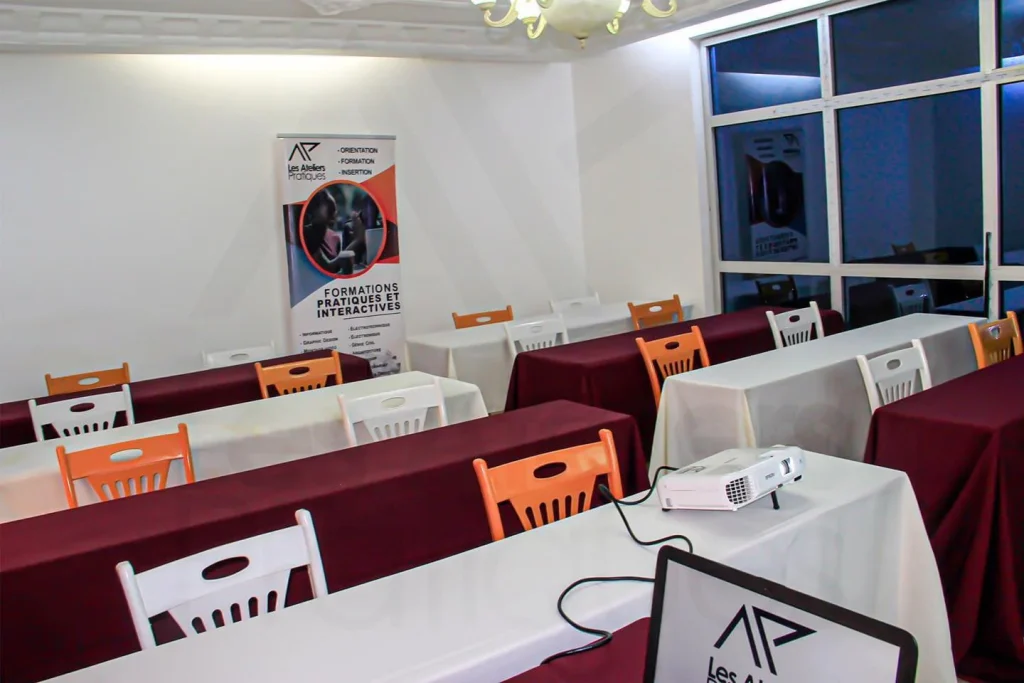 Salle de séminaire en configuration classe, prête à accueillir une session