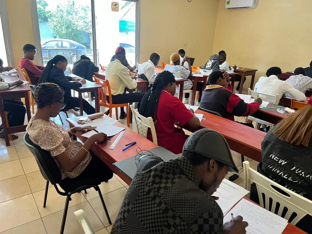 Une quinzaine d'apprenants en salle de classe pendant une évaluation écrite